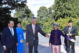 Thủ tướng Singapore Lý Hiển Long đón Thủ tướng Nguyễn Xuân Phúc và Phu nhân. (Ảnh: Thống Nhất/TTXVN)