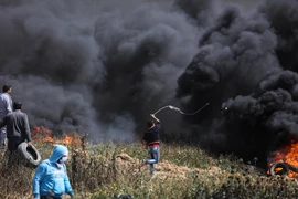 Người biểu tình Palestine đốt lốp xe và ném đá vào binh sỹ Israel. (Nguồn: THX/TTXVN)