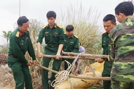 Lực lượng chức năng vận chuyển quả bom về vị trí hủy nổ an toàn. (Ảnh: TTXVN phát)