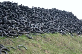 Bãi rác thải, vỏ lốp xe ngổn ngang ven đường đê tại thôn Thu Thủy, xã Xuân Thu, huyện Sóc Sơn. (Ảnh: Hùng Võ/Vietnam+)