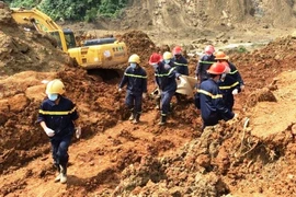 Lực lượng tìm kiếm cứu nạn đưa các nạn nhân ra khỏi hiện trường vụ sạt núi. (Ảnh. H.V/Vietnam+)