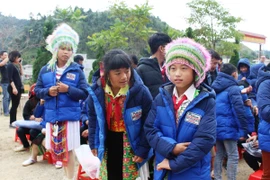 Các em học sinh Trường phổ thông bán trú trung học cơ sở Tả Ván vui mừng khi nhận được áo ấm từ đoàn thiện nguyện. (Ảnh: Hùng Võ/Vietnam+)