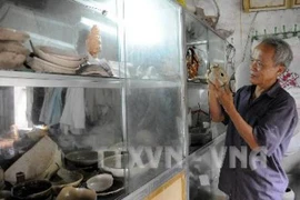 Ông Hồng bên những cổ vật tìm được (Ảnh: TTXVN)