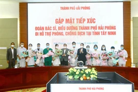 Lãnh đạo thành phố Hải Phòng tặng hoa động viên các bác sỹ, điều dưỡng tại buổi gặp mặt. (Ảnh: An Đăng/TTXVN) 