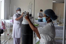 Nhân viên y tế chuẩn bị bình ôxy cho bệnh nhân COVID-19 tại Kolkata, Ấn Độ. (Ảnh: THX/TTXVN) 