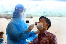 Cán bộ y tế lấy mẫu xét nghiệm cho người dân phường Hà Huy Tập, thành phố Vinh, tỉnh Nghệ An (sáng 14/6/2021). (Ảnh: Tá Chuyên/TTXVN)