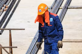 Công nhân làm việc tại các công trường phải dấp nước quấn khăn quanh đầu trước nắng nóng gay gắt có lúc lên hơn 40 độ C. (Ảnh: Thành Đạt/TTXVN) 