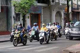 Người dân Thành phố Hồ Chí Minh thực hiện đeo khẩu trang phòng chống dịch COVID-19 khi tham gia giao thông. (Ảnh: Thanh Vũ/TTXVN) 