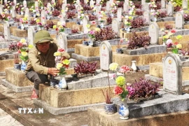 Cựu chiến binh Cáp Kim Xinh chăm sóc phần mộ liệt sỹ tại Nghĩa trang Liệt sỹ xã Cam Chính, huyện Cam Lộ, tỉnh Quảng Trị. (Ảnh: Nguyên Lý/TTXVN)