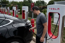 Người dân sạc điện cho ôtô tại một trạm sạc của Tesla ở Arlington, Virginia, Mỹ. (Ảnh: AFP/TTXVN)