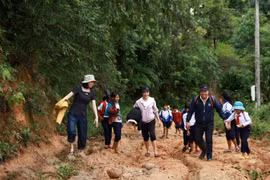 Cô Hồ Thị Thùy Vân (ngoài cùng bên trái), cùng đồng nghiệp vận động đưa học sinh đến lớp. (Nguồn: baodantoc.vn) 