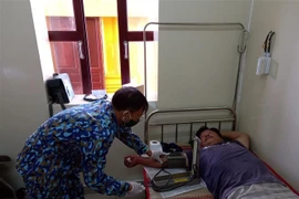 Quân y Nhà giàn DK-I/19 khám, điều trị cho ngư dân Nguyễn Văn Thanh. (Nguồn: TTXVN phát) 
