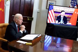 Tổng thống Mỹ Joe Biden (trái) và Chủ tịch Trung Quốc Tập Cận Bình (trên màn hình) trong cuộc hội đàm thượng đỉnh trực tuyến, tại Washington DC., ngày 15/11/2021. (Ảnh: AFP/TTXVN) 