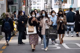 Người dân đeo khẩu trang phòng dịch COVID-19 khi đi trên đường phố tại Seoul, Hàn Quốc, ngày 18/4/2021. (Nguồn: Bloomberg/TTXVN) 