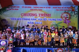 Tặng quà cho trẻ em có hoàn cảnh khó khăn. (Ảnh: Lê Sen/TTXVN)