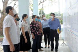 Người dân thôn Đồng Mà, xã Trung Yên, huyện Sơn Dương (Tuyên Quang) tìm hiểu thông tin về các ứng cử viên được niêm yết tại nhà văn hóa thôn. (Ảnh: Vũ Quang/TTXVN)