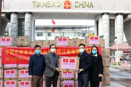 Lãnh đạo Sở Ngoại vụ, Sở y tế tỉnh Hà Giang tiếp nhận vật tư y tế do châu Văn Sơn, tỉnh Vân Nam (Trung Quốc) trao tặng. (Ảnh: Nguyễn Chiến/TTXVN) 