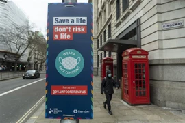 Biển hiệu khuyến khích người dân đeo khẩu trang phòng dịch COVID-19 tại London, Anh ngày 21/2/2022. (Ảnh: THX/TTXVN) 