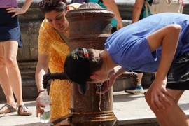 Người dân uống nước để giải nhiệt tại Rome, Italy, ngày 18/7/2023. (Ảnh: THX/TTXVN)