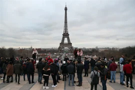 Khách du lịch chụp ảnh bên Tháp Eiffel ở thủ đô Paris, Pháp. (Ảnh: AFP/TTXVN)