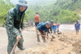 Cán bộ chiến sỹ Đồn Biên phòng Ra Mai, Bộ đội Biên phòng Quảng Bình hỗ trợ cùng nhân dân trên địa bàn khắc phục sạt lở đất đá, khơi thông các tuyến đường trọng yếu. (Ảnh: TTXVN phát) 