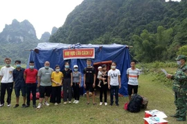 12 công dân nhập cảnh trái phép được cán bộ, chiến sỹ Đồn Biên phòng Lý Quốc (Cao Bằng) phát hiện, tạm giữ. (Nguồn:TTXVN phát) 