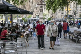 Người dân đeo khẩu trang phòng tránh COVID-19 tại một khu phố ở Barcelona, Tây Ban Nha. (Nguồn: THX/TTXVN) 