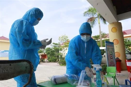 Nhân viên y tế chuẩn bị lấy mẫu xét nghiệm. (Ảnh: Hoàng Hùng/TTXVN) 