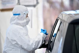 Nhân viên y tế lấy mẫu xét nghiệm COVID-19 cho người dân tại Minsk Mazowiecki, Ba Lan ngày 26/1/2022. (Ảnh: PAP/TTXVN) 