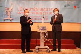 Ông Trần Ngọc Phúc (phải) bàn giao máy thở cho Đại sứ Vũ Hồng Nam. (Ảnh: Đức Thịnh/TTXVN)