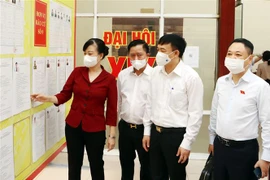 Các đại biểu kiểm tra niêm yết tiểu sử người ứng cử tại Ủy ban Nhân dân huyện Quế Võ, tỉnh Bắc Ninh. (Ảnh: Thanh Thương/TTXVN) 