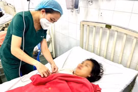 Bác sỹ thăm khám cho sản phụ sau ca sinh non do sốt xuất huyết. (Ảnh: TTXVN phát) 