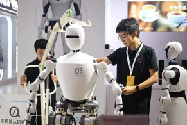 Một nhân viên kiểm tra robot hình người tại Triển lãm Robot Thế giới 2024. (Nguồn: GT)