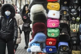 Người dân đeo khẩu trang phòng lây nhiễm dịch COVID-19 trên một đường phố ở Moskva, Nga. (Nguồn: AFP/TTXVN) 