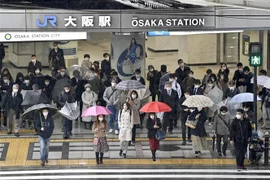 Người dân đeo khẩu trang phòng dịch COVID-19 khi đi trên đường phố ở Osaka, Nhật Bản ngày 22/3/2022. (Ảnh: Kyodo/TTXVN) 