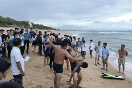 Các thành viên Đội cứu hộ bờ biển Trung tâm Cung ứng Dịch vụ Công ích thành phố Tuy Hòa sơ cứu cho các nạn nhân đuối nước. (Ảnh: Phạm Cường/TTXVN) 