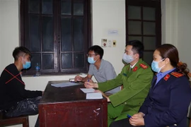 Cơ quan chức năng lấy lời khai của đối tượng Hùng. (Nguồn: TTXVN phát) 