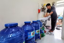 Trung bình mỗi tháng, người dân sống tại hẻm 111, đường Võ Văn Kiệt phải chi thêm khoảng 200 nghìn đồng để mua nước lọc dùng cho ăn uống. (Ảnh: Thanh Liêm/TTXVN) 