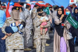 Binh sỹ Saudi Arabia bế em bé Sudan sơ tán tránh xung đột, tại căn cứ hải quân ở Jeddah, ngày 26/4/2023. (Ảnh: AFP/TTXVN)