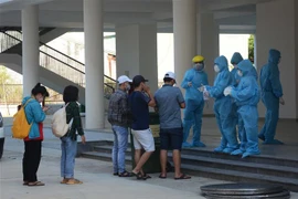 Nhân viên y tế thực hiện quy trình tiếp đón các trường hợp F1 được cách ly tại Khu ký túc xá phía Tây thành phố Đà Nẵng. (Ảnh: Văn Dũng/TTXVN)