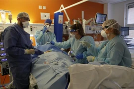 Nhân viên y tế điều trị cho bệnh nhân COVID-19 tại bệnh viện ở London, Anh. (Ảnh: AFP/TTXVN) 