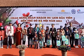 Lãnh đạo Sở Du lịch Hà Nội tặng quà cho đoàn khách đầu tiên năm 2021. (Ảnh: Đinh Thuận/TTXVN) 