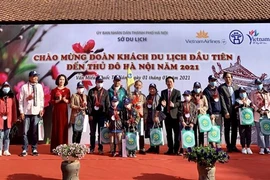 Lãnh đạo Sở Du lịch Hà Nội tặng quà cho đoàn khách đầu tiên năm 2021. (Ảnh: Đinh Thuận/TTXVN) 
