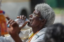 Người dân uống nước giải nhiệt trong thời tiết nắng nóng gay gắt tại New Delhi, Ấn Độ, ngày 23/5/2023. (Ảnh: THX/TTXVN)