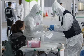 Nhân viên y tế lấy mẫu dịch của hành khách để xét nghiệm COVID-19 tại sân bay quốc tế Incheon, Hàn Quốc, ngày 27/3/2020. (Nguồn: THX/TTXVN) 