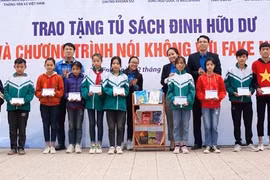 Trao tặng biểu trưng Tủ sách Đinh Hữu Dư cho trường THCS Trần Kim Xuyến. (Ảnh: Hoàng Ngà/TTXVN) 