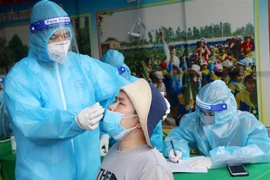 Nhân viên y tế lấy mẫu xét nghiệm sang lọc cho người dân phường Gia Cẩm, thành phố Việt Trì. (Ảnh: Trung Kiên/TTXVN). 