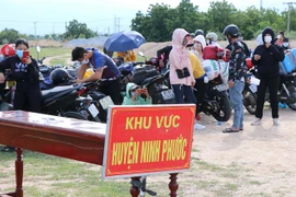 Người dân từ Đồng Nai về được tập trung theo khu vực để kiểm tra dịch bệnh trước khi đưa đi cách ly tập trung. (Ảnh: Công Thử/TTXVN) 