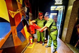 Đoàn kiểm tra của Công an quận 8 kiểm tra các điều kiện về an toàn phòng cháy chữa cháy tại quán Karaoke ICool. (Ảnh: TTXVN phát) 
