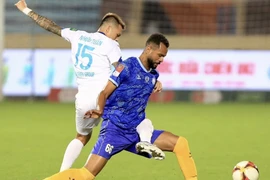 Pha phá bóng trước khung thành trong trận đấu giữa Câu lạc bộ Thép Xanh Nam Định và Câu lạc bộ Khánh Hòa. (Ảnh: Công Luật/TTXVN)